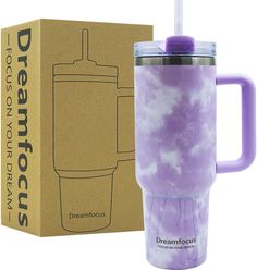 a purple coffee cup with a straw in it next to a cardboard box that says dreamfocuss