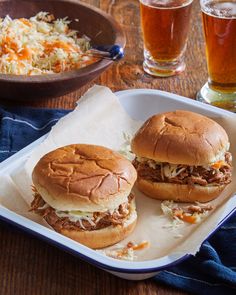 two pulled pork sandwiches with cole slaw and beer