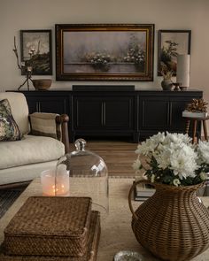 a living room filled with lots of furniture and flowers on top of a coffee table