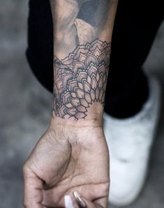 a person with a tattoo on their arm and hand holding something in the other hand