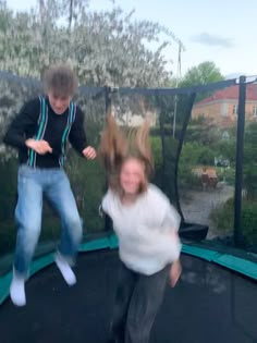 two young children jumping on a trampoline