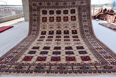 an old rug is on display in a room with other rugs and blankets around it