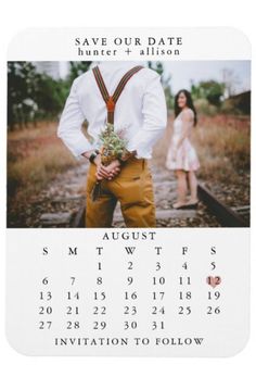 a couple standing next to each other in front of a calendar with the date on it