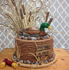 there is a cake made to look like a duck and reeds on the table