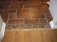 a tile floor in a bathroom with wood floors