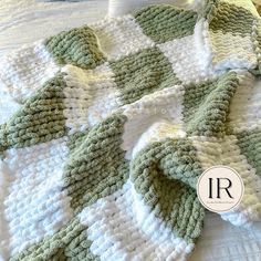 a crocheted blanket on top of a bed with the letter r in it