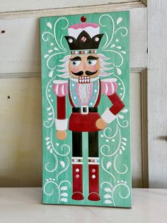 a wooden sign with a nutcracker painted on it