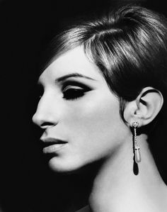 a black and white photo of a woman wearing earrings