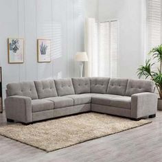 a gray sectional couch sitting on top of a rug