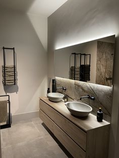 a bathroom with two sinks and towels hanging on the wall