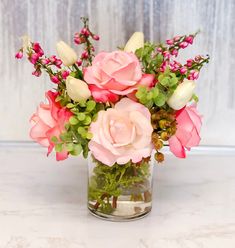 a glass vase filled with pink and white flowers