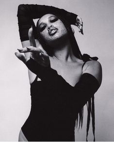 a black and white photo of a woman with freckles on her head, holding her hands up to her face