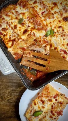 a pizza sitting on top of a white plate next to a wooden spatula filled with cheese