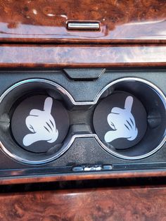 two speakers in the center of a car with hand prints on them and wood grained finish