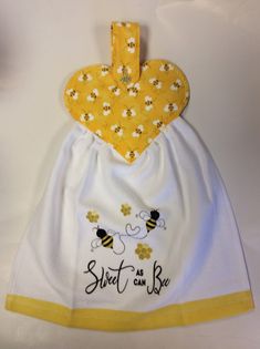 a yellow and white bib with bees on it that says sweet as can bee