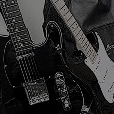 two electric guitars are sitting next to each other on a black and white background,