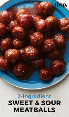 a blue plate topped with meatballs covered in sauce