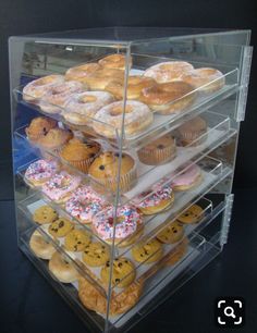 a display case filled with lots of different types of doughnuts on top of each other