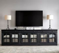 an entertainment center with a large flat screen tv mounted on it's sideboard