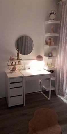 a white desk with a mirror and lamp on it's side, in front of a window