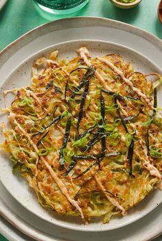 an omelet on a white plate with green onions