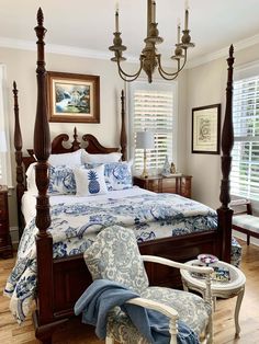 a bedroom with four poster bed, blue and white decor