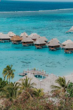 an aerial view of some huts in the water