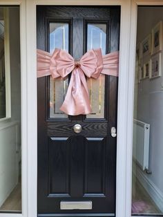 a black door with a pink bow on it