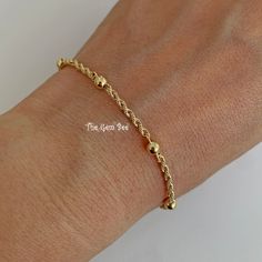 "Thank you for coming in! Genuine 14K SOLID YELLOW GOLD bracelet with 6 ball/bead stations and a spring ring clasp. THEY ARE STAMPED WITH \"585\", but we could not show it clearly in the pictures. Made in Italy! Super cute! You'll get a 7 inch bracelet per winning! We also have 18 inch and 16 inch necklace options in our shop! DIMENSION: 2.2mm rope width, 4mm spheres, 5mm spring ring clasp. WEIGHT: 2 gram MATERIAL: 14K Yellow Gold" Adjustable Gold Bracelet With Beaded Chain, Yellow Gold Plated Chain Bracelet With Round Beads, Adjustable Gold Beaded Chain Bracelet, Gold 14k Gold Bracelets With Satellite Chain, Gold Adjustable Ball Chain Bracelet, Yellow Gold Plated Bracelets With Satellite Chain, Gold-plated Chain Bracelet With Gold Beads, Gold Ball Chain Bracelet Gift, Adjustable Yellow Gold Bracelet With Satellite Chain