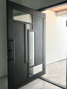 an open door with glass panels on the inside and outside doors, in front of a white wall