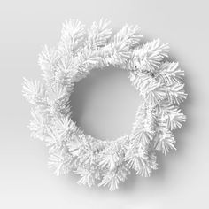 a white wreath with snow flakes hanging from it's sides on a gray background