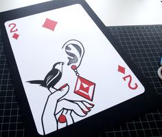 a playing card with a bird on it next to some scissors and other items that include scissors