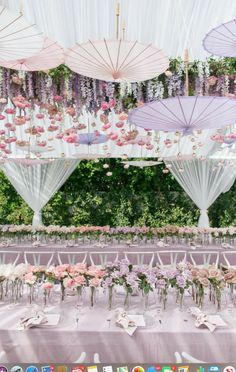 an outdoor wedding setup with flowers and umbrellas