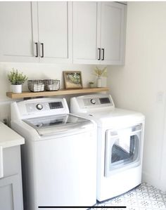 a white washer and dryer sitting next to each other in a laundry room