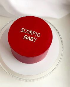 a red cake with the words scorpio baby on it sitting on a plate