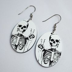 a pair of earrings with a skeleton on it