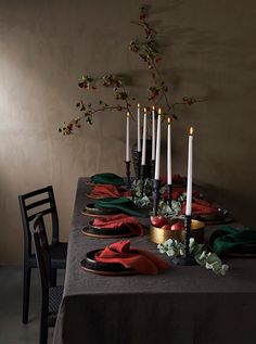 the table is set with many candles and place settings for four people to sit at