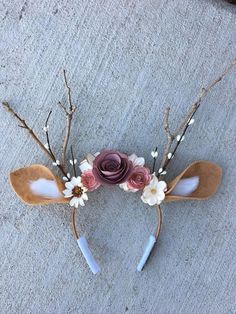 a pair of wooden spoons with flowers and leaves on them sitting on the ground