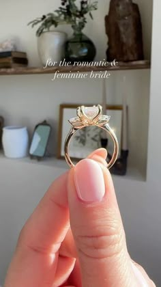 a person holding up a wedding ring in their hand