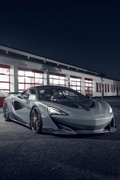 a silver sports car parked in front of a building