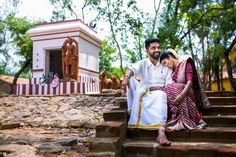 a man and woman sitting on some steps