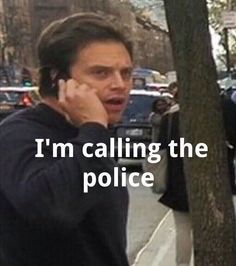 a man talking on a cell phone while standing next to a tree with the words i'm calling the police