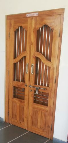 two wooden doors with metal bars on them