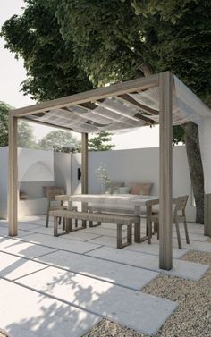 an outdoor dining area with table and chairs under a tree in the middle of it