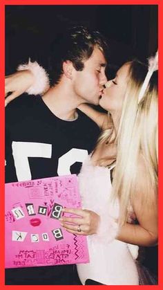 a man and woman kissing each other in front of a pink sign with letters on it