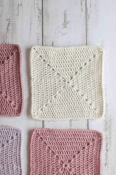 three crocheted squares are shown on a white wooden surface