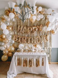 a birthday party with gold and white balloons