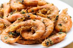 cooked shrimp with herbs and seasoning on a white plate