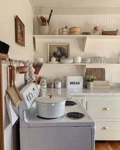 a white stove top oven sitting inside of a kitchen next to a wall mounted shelf