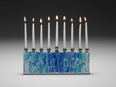 a menorah with seven candles in it and blue mosaic tiles on the bottom